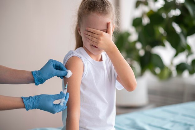 Little girl vaccinating for coronavirus at the hospital