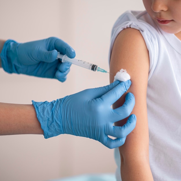 Little girl vaccinating for coronavirus at the hospital