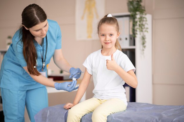 Little girl vaccinating for coronavirus at the hospital