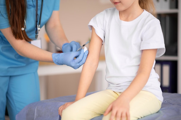 Free photo little girl vaccinating for coronavirus at the hospital