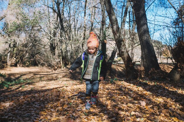 Little girl walking on foliage