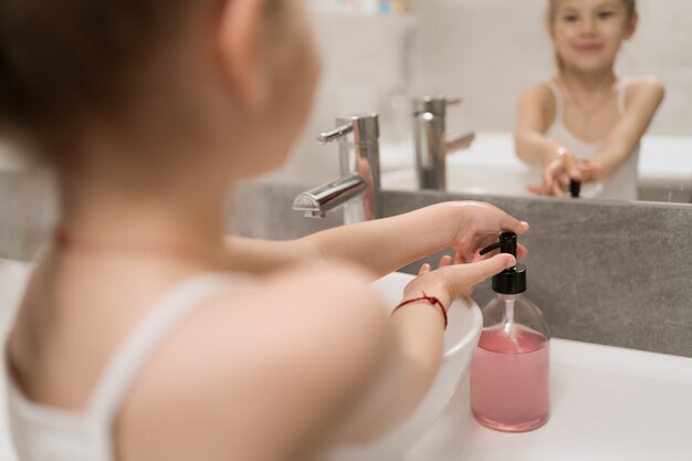 Little girl washing hands with soap