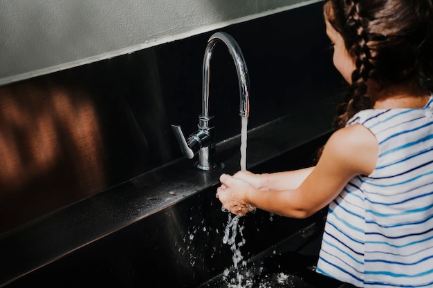 Free photo little girl washing her hands in school.