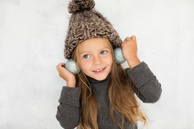 Little girl wearing christmas globes as earrings