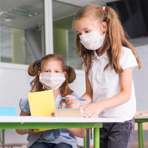 Bambina indossa maschere mediche a scuola