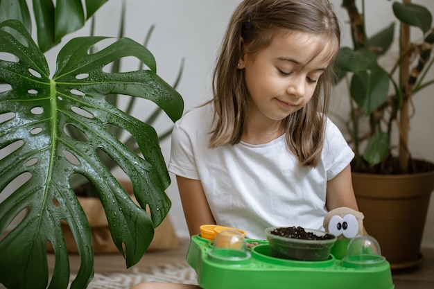 A little girl with a baby kit for growing a plant on her own.