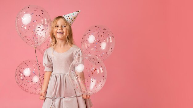 Little girl with balloons in costume and copy space