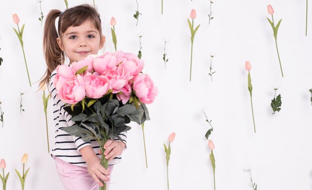 Маленькая девочка с красивым букетом роз