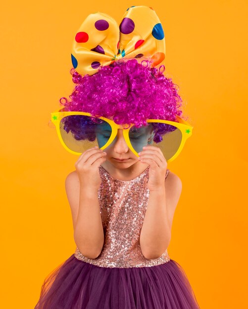 Little girl with big sunglasses and clown wig