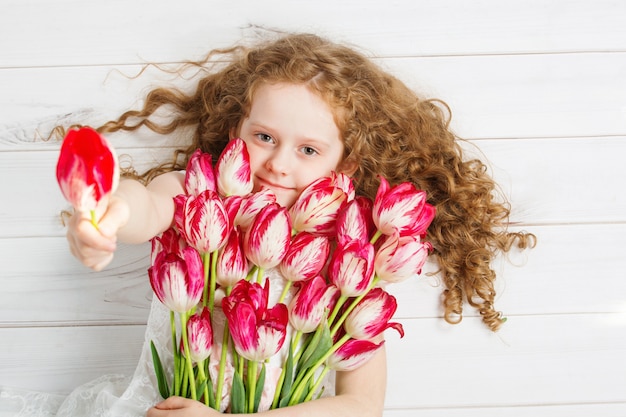 Little girl with bouquet of tulips. mothers day concept, holiday concept.