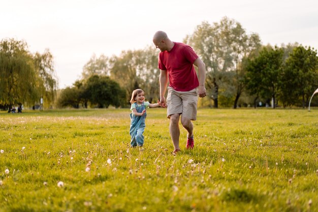 little girl with dad. dad throws baby up in the air. cheerful laughter, emotional child, happiness.