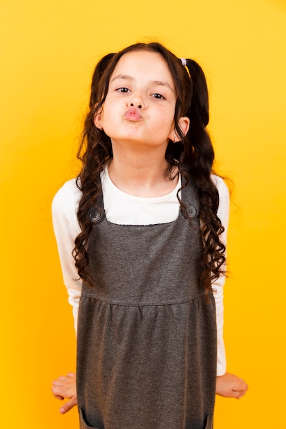 Little girl with dress doing kiss pose