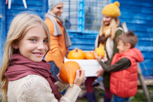 Foto gratuita bambina con la famiglia durante il raccolto autunnale