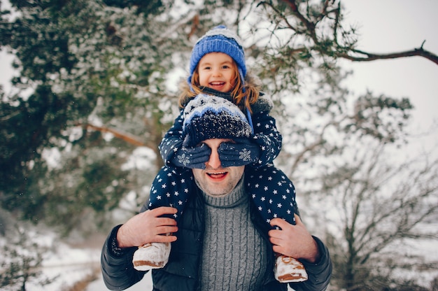 Little girl with father playing in a winter park