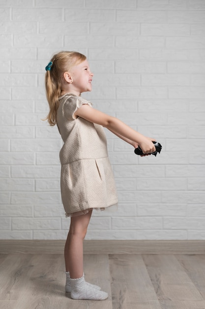 Little girl with joystick in hands at home