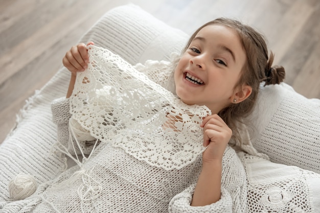 天然綿糸のレースナプキンを手でかぎ針編みした少女。趣味でかぎ針編み。