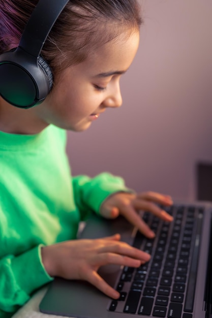 Маленькая девочка с ноутбуком играет в игры с концепцией игровой зависимости