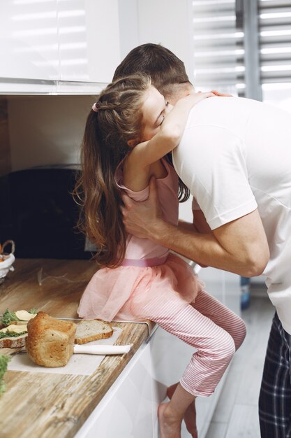 Little girl with long hair. Father and daughter together. Family prepares to eat.