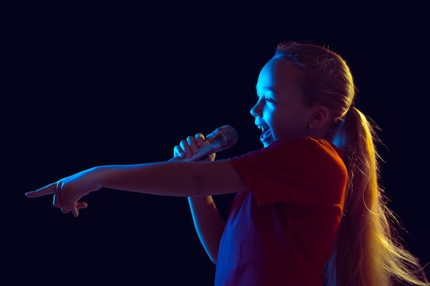 Маленькая девочка с микрофоном в неоновом свете