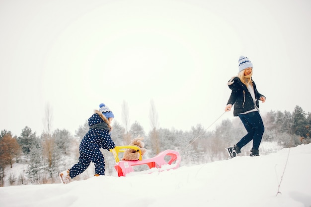 Foto gratuita bambina con la madre che gioca in un parco d'inverno
