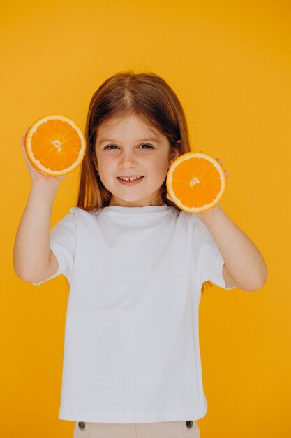 Little girl with oranges isolated in studio