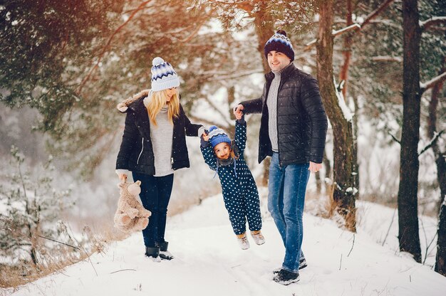 little girl with parents playing in a winter park
