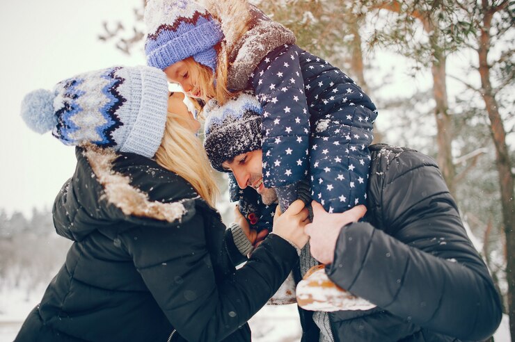 Free Photo little girl with parents playing in a winter park
