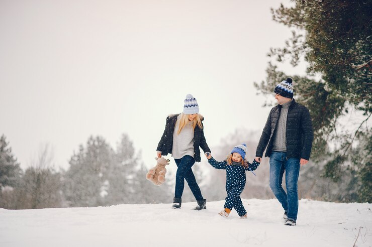 Free Photo little girl with parents playing in a winter park