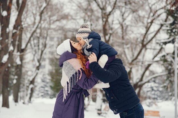 Bambina con i genitori in un parco di inverno