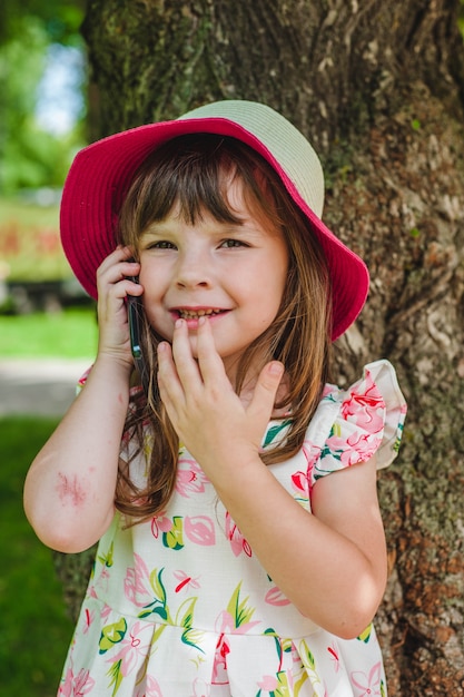 전화 통화하는 분홍색 모자와 어린 소녀