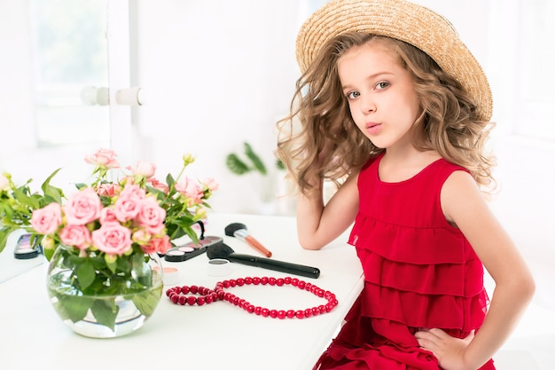 A little girl with red dress and cosmetics.