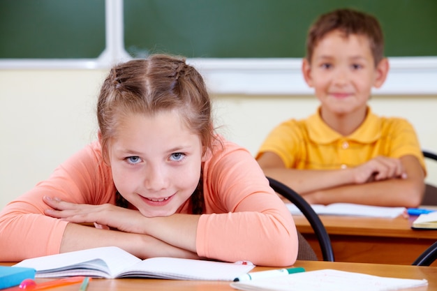 Little girl with schoolboy on background