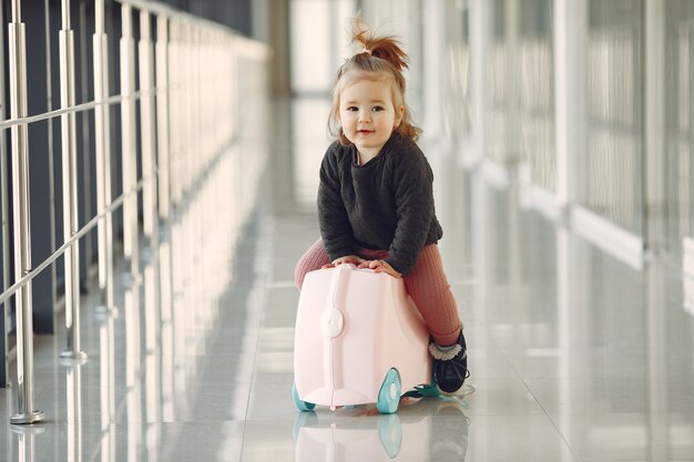 Little girl with a suitcase at the airport