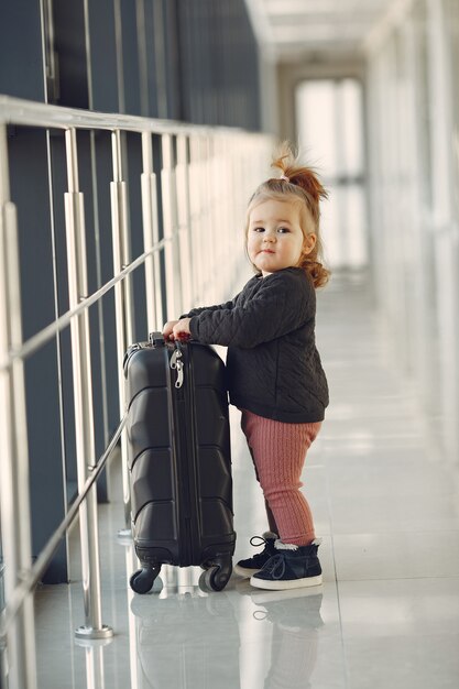 Little girl with a suitcase at the airport