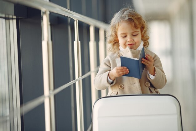 Little girl with a suitcase at the airport