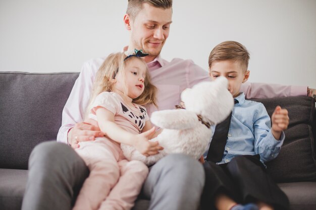 Little girl with teddy bear sitting on her father