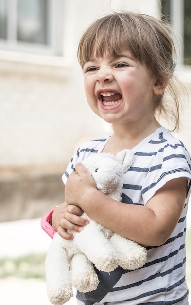 Free photo little girl with toy lamb