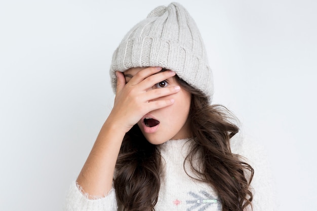 Foto gratuita la bambina con l'inverno copre la vista frontale