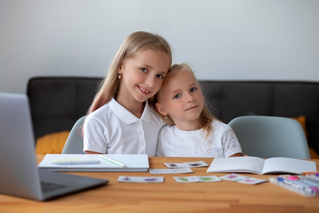 Бесплатное фото Маленькие девочки вместе учатся в онлайн-школе дома