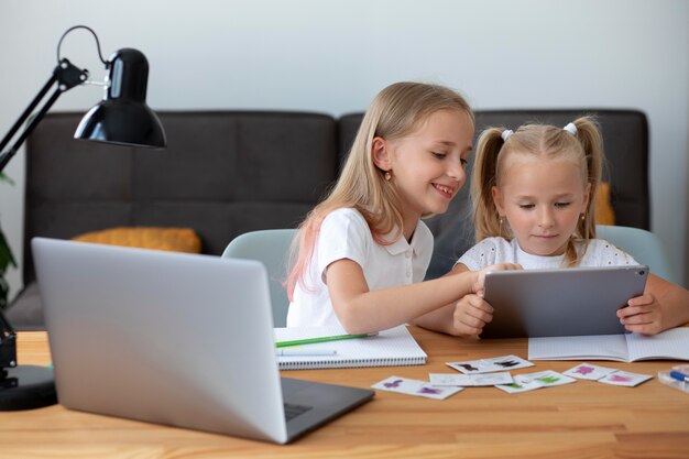 Little girls doing online school together at home