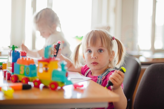 Little girls drawing in playroom