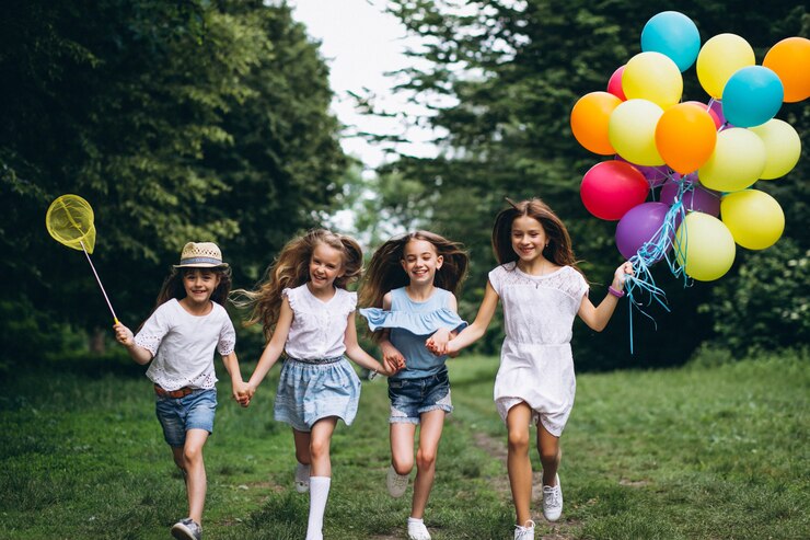 Free Photo little girls friends with balloons in forest