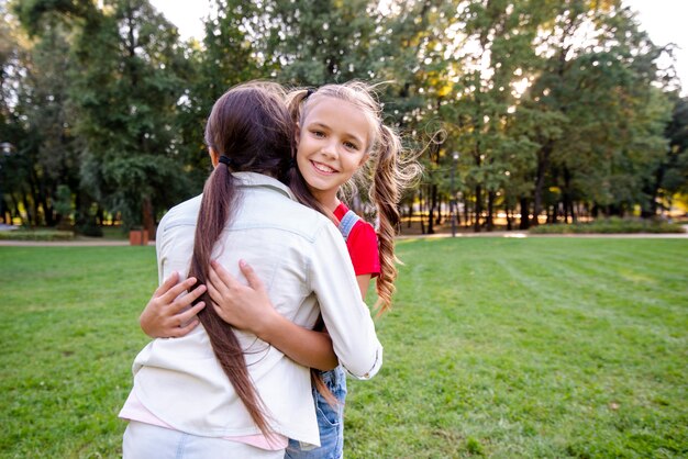 Маленькие девочки обнимаются в парке