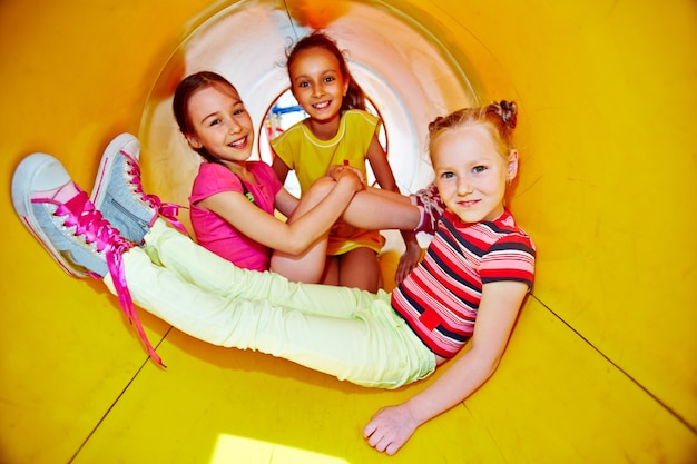 Free photo little girls playing on slide at playground