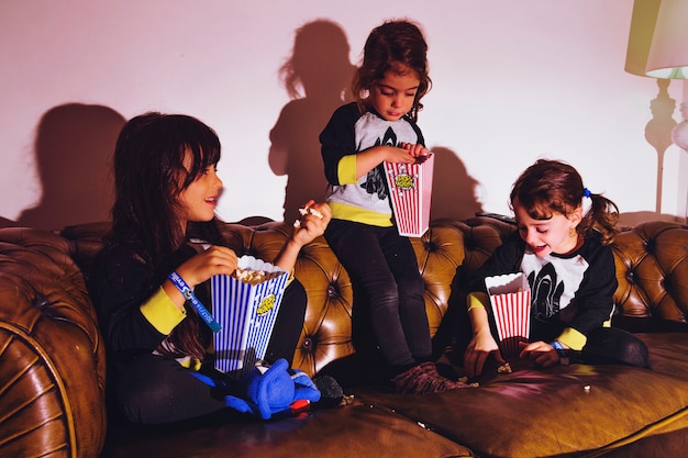 Little girls with popcorn on couch