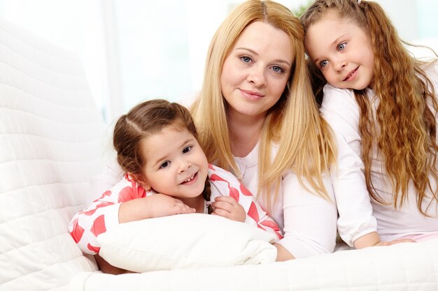 Little girls with their mother sitting on the couch