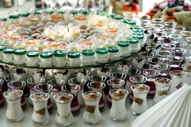 Little glasses with cold desserts stand side by side