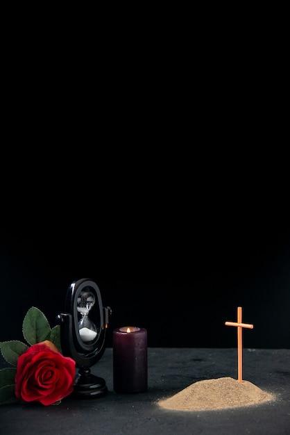어두운 표면에 붉은 꽃과 모래 시계가 기억으로있는 작은 무덤