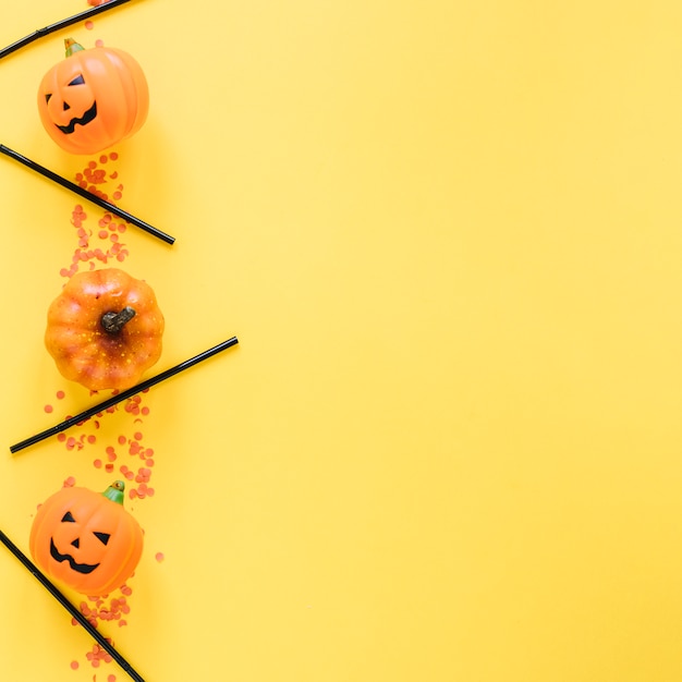 Piccole zucche di halloween e tubi di plastica disposti in linea