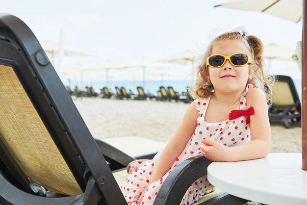 海沿いのサンベッドで幸せな少女